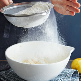 Mürbeteig zubereiten - Step 3: Mehl und Backpulver mischen und in die Masse sieben. Mürbeteig - Mehl sieben