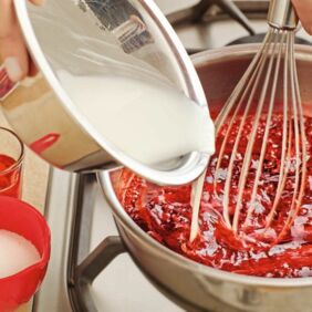 Die Stärke mit 3-4 EL Wasser verrühren und unter Rühren in den kochenden Fruchtsaft gießen. 2-3 Min. kochen lassen, bis die Stärke bindet. Rote Grütze Step 3