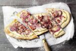 Zu den bekanntesten französischen Rezepten zählt der Elsässer Flammkuchen: Ein dünner Teig, bestrichen mit Crème fraîche und belegt mit Speck und Zwiebeln Französische Rezepte