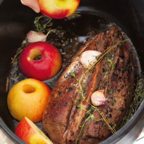 Rehrücken zusammen mit Gewürzen und Äpfeln im Bräter garen. Rehrücken im Bräter