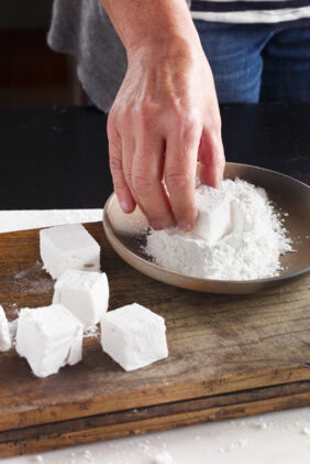 Marshmallows in Puderzucker wälzen Marshmallows in Puderzucker wälzen