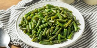 Gekochte grüne Bohnen auf einem Teller. Bohnensalat Rezept Bohnensalat