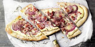 Zu den bekanntesten französischen Rezepten zählt der Elsässer Flammkuchen: Ein dünner Teig, bestrichen mit Crème fraîche und belegt mit Speck und Zwiebeln Französische Rezepte
