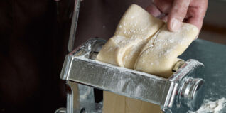 Nudelteig durch die Nudelmaschine führen Nudelteig durch die Nudelmaschine führen